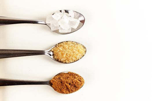 Brown cane sugar in a metal spoon on the white background. Pure cane sugar for natural. no additives.