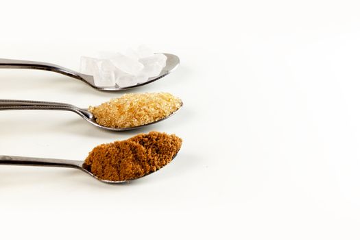 Brown cane sugar in a metal spoon on the white background. Pure cane sugar for natural. no additives.