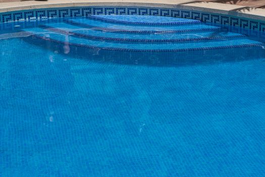 Outdoor swimming pool, whirlpool with stone steps and blue tiles