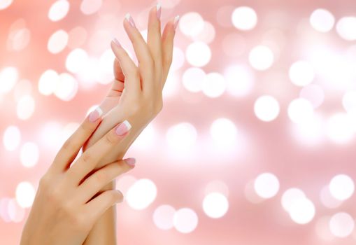 Beautiful woman hands against an abstract background with blurred lights
