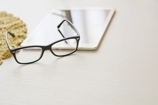 glasses and tablet on a white table