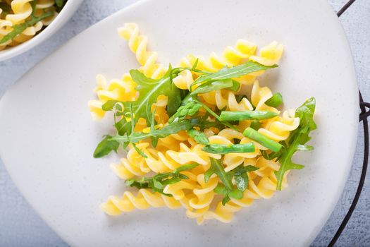 Pasta salad with asparagus and arugula on a plate