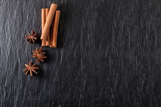 Cinnamon sticks, anise on a stone plate.