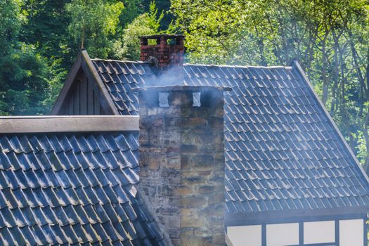 Smoking chimney on the roof of a house.