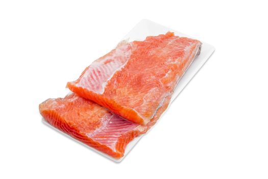 Two pieces of fresh uncooked fillet of rainbow trout on a rectangular white plate on a light background 
