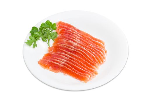 Sliced fillet of salted rainbow trout and a sprig of parsley on a white dish on a light background 
