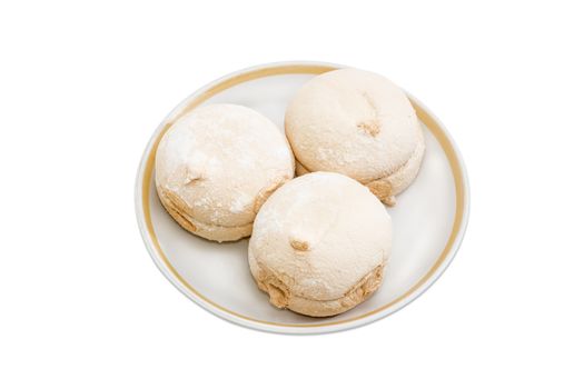 Light coffee-colored zefir - soft confectionery similar to marshmallow on a saucer on a light background
