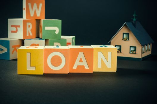 LOAN word with colorful blocks. loan word debt forecasting money financial cube repaying concept