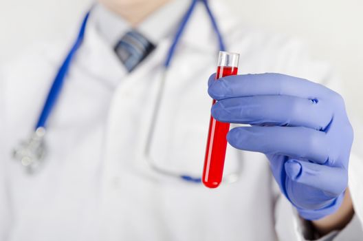 Doctor holds a tube of red fluid. test tube laboratory medical doctor red research lab concept