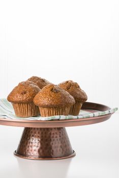 Raisin bran muffins on a copper presentation platter.