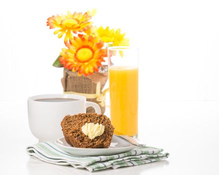 Fresh bran muffin served with coffee and orange juice.