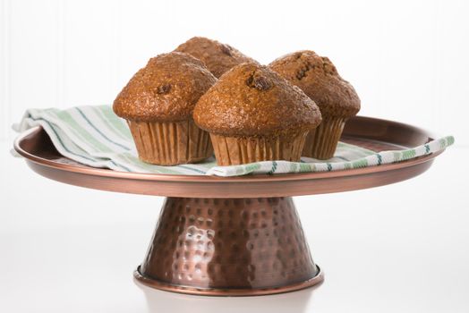Fresh raisin bran muffins on a copper presentation platter.