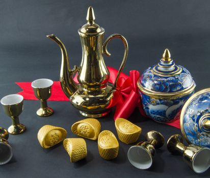 Gold ingot Benjarong  Red ribbon bow Gold jug Tea glass wedding Chinese  black background