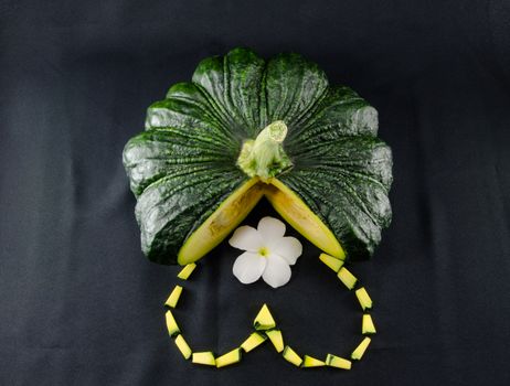 Sliced raw yellow pumpkin on black background. Sliced yellow pumpkin and green pumpkin for use as cooking ingredients