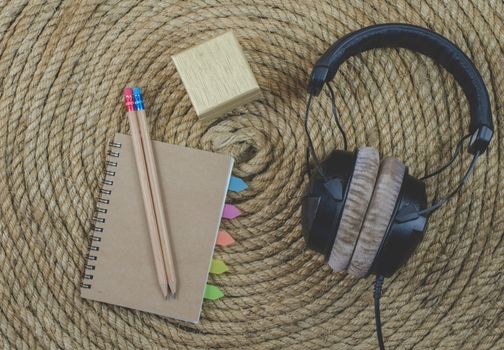 notebook and headphone music  on a jute rope background