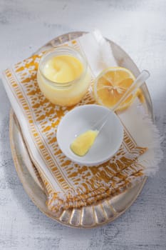 Lemon kurd with a spoon served on a table.