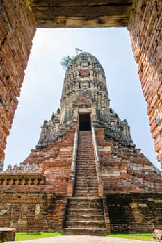 Large ancient pagoda looking through the door frame of Wat Chaiwatthanaram is buddhist temple, famous and major tourist attraction religion, Phra Nakhon Si Ayutthaya Historical Park, Thailand