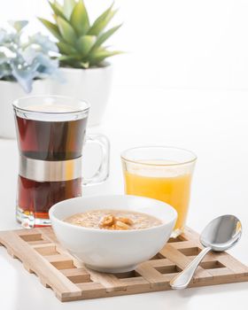 Bowl of maple walnut flavored oatmeal with coffee and juice.