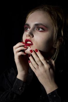 Young girl vampire on a black background