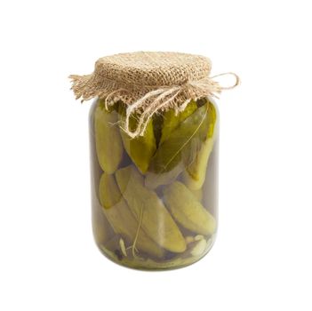 Canned cucumbers with spices in glass jar on a light background
