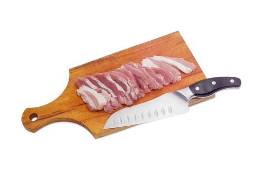 Sliced fresh uncooked pork belly with layers of muscle and fats and kitchen knife on a wooden cutting board on a light background 
