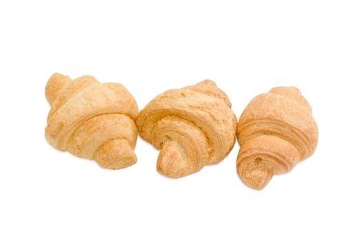 Three small baked croissant on a light background
