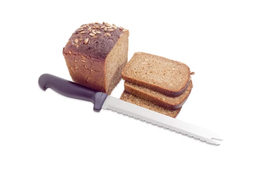 Partly sliced brown bread with whole grain of a sunflowers and kitchen knife on a light background
