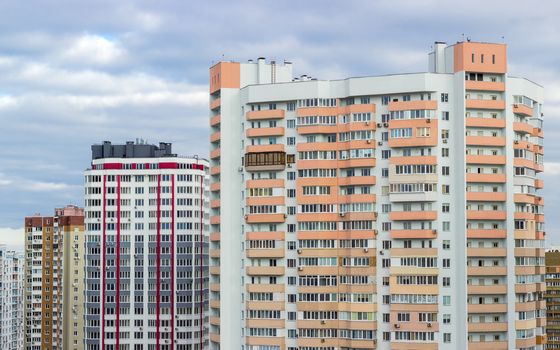 Fragment of a housing estate with typical modern multi-storey apartment buildings in a big city cloudy day
