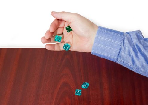 Specialized polyhedral dice with numbers used in role-playing games thrown from male hand on a wooden surface
