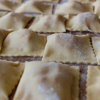 Texture of italian Ravioli Pasta on wooden table.