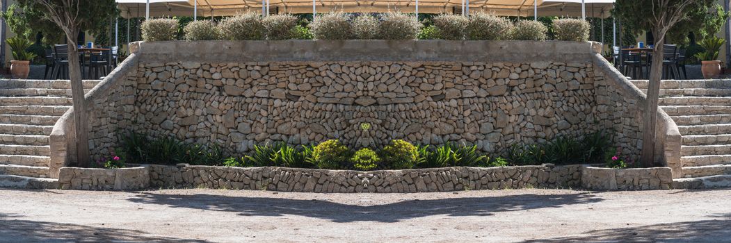 Mediterranean retaining wall of traditional natural stone for a terrace of a restaurant.