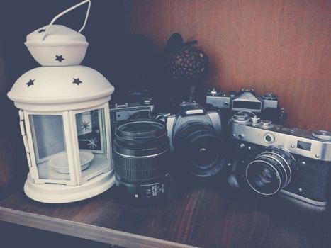 camera and lenses laying on brown wooden background