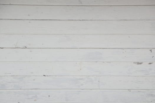 Old horizontal white painted boards on a boathouse. Weathered and a little grungy