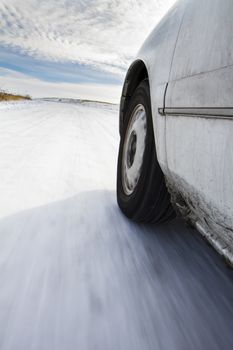 Car driving down the road in the winter snow