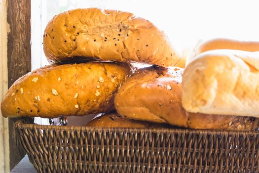 fresh bread buns in a basket on a wooden table