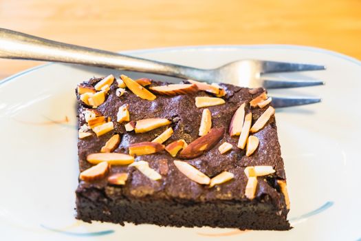 almond chocolate brownie cake on white dish and fork