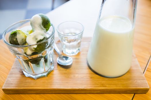 matcha ice cream and fresh milk in glass on wooden table