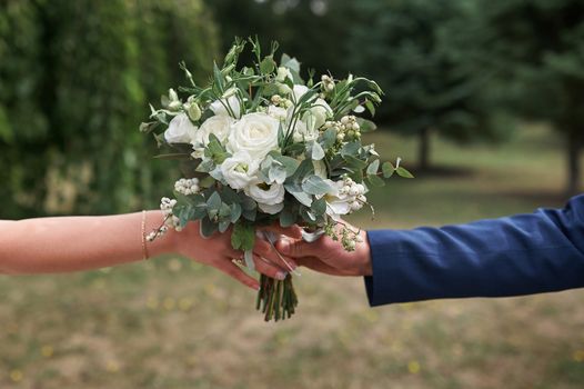 groom gives the bride a beautiful bridal bouquet.
