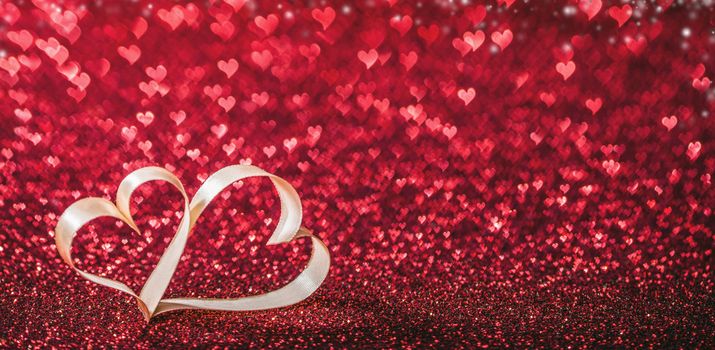 Two ribbon hearts on glowing bokeh lights background