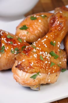 Fried chicken leg with sesame seeds in a plate closeup