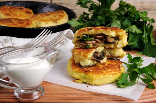 Potato cakes (zrazy) Stuffed mushrooms with herbs of the table with sour cream