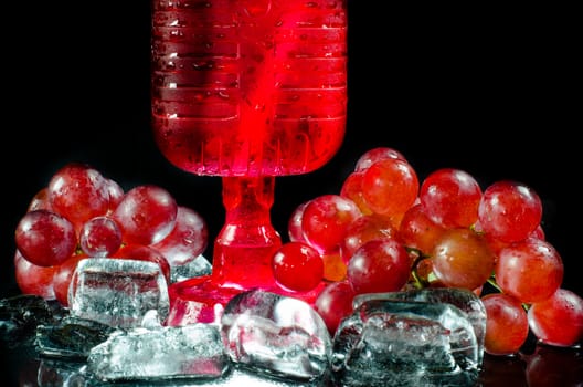 Glasses  red wine and  grape closeup a black background.