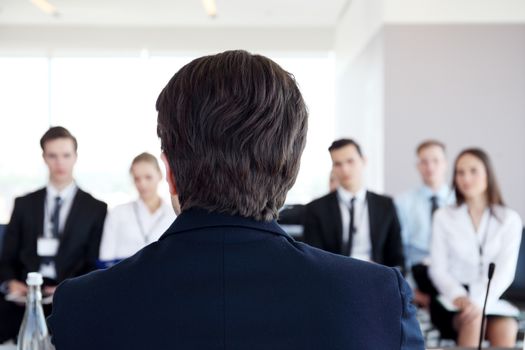 Speaker at business conference looking at audience waiting for questions