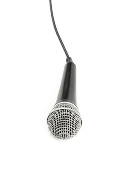 Black and silver vocal microphone with cable high angle view close up isolated on white background, personal perspective