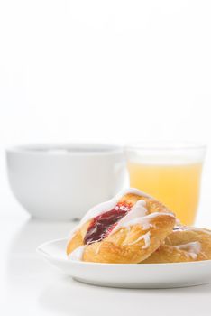 Fresh raspberry danish with coffee and orange juice.