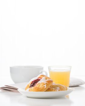 Fresh raspberry danish and coffee with the morning newspaper in the background.