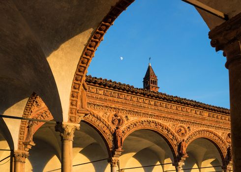 Grand Cloister of the Certosa di Pavia monastery,features columns with precious decorations in terracotta portraying saints, prophets and angels, in white and pink Verona marble,at sunset,Italy.