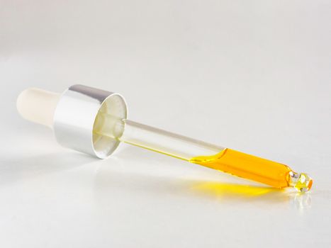 Essential oil or serum in pipette on white background close up