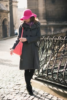 the girl with the hat walks around the city