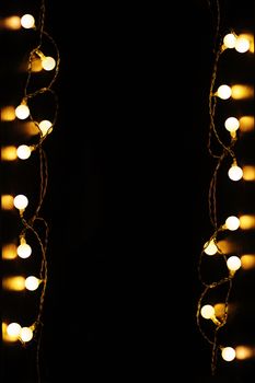 festive frame of Garland on a black background with space for text.